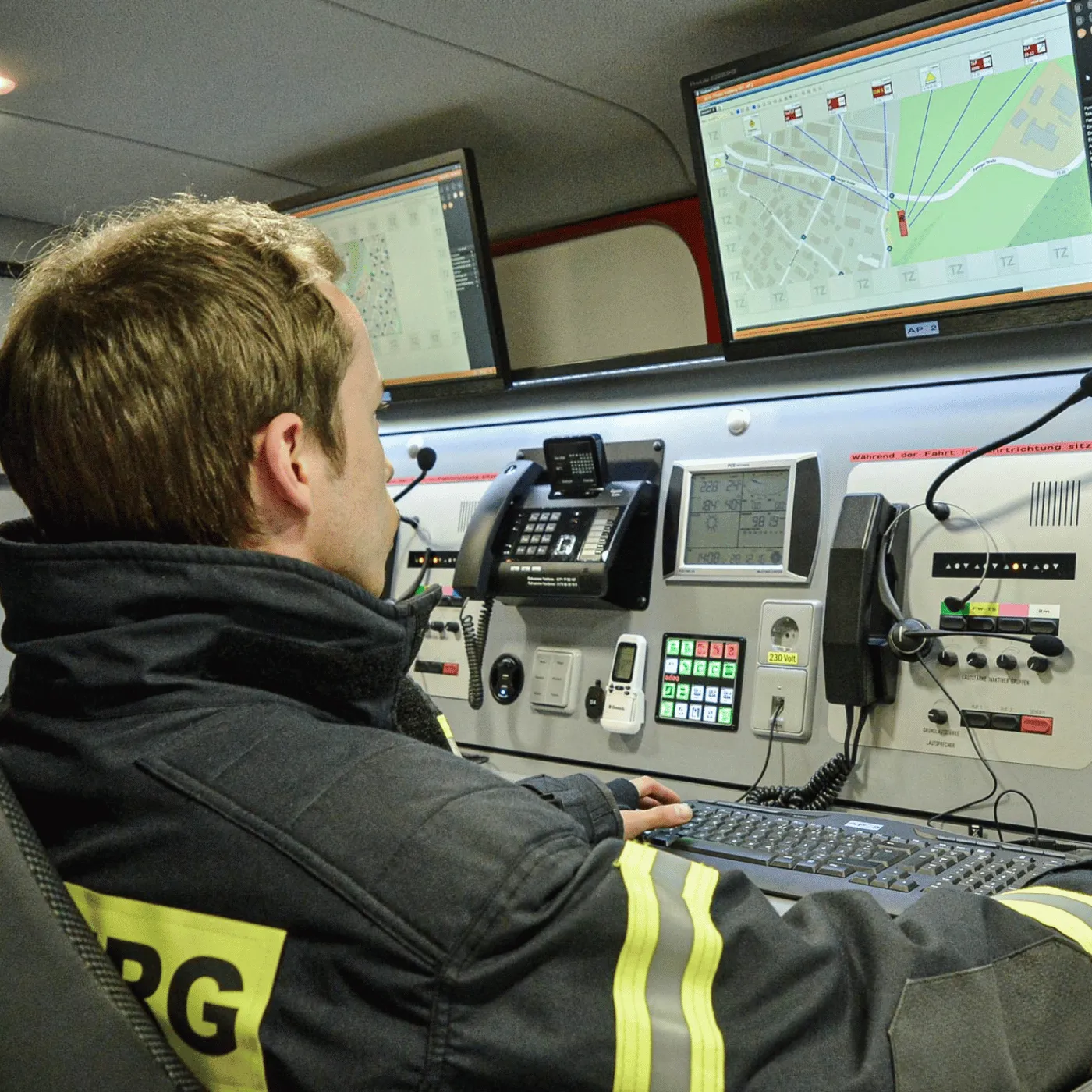 Ein Mitarbeiter von Fireboard GmbH in dunkler Schutzkleidung schaut auf einen Bildschirm.