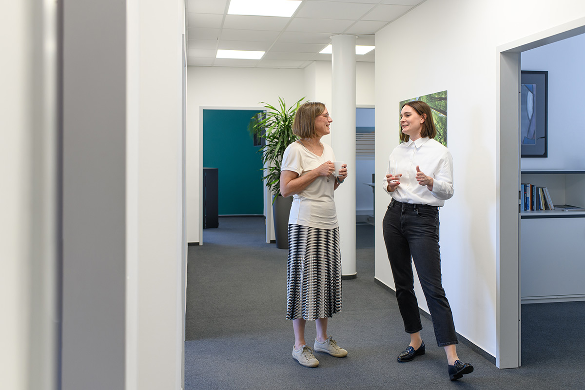 Symbolbild Abacus Experten GmbH bei Abacus alpha: Zwei Mitarbeiterinnen unterhalten sich.