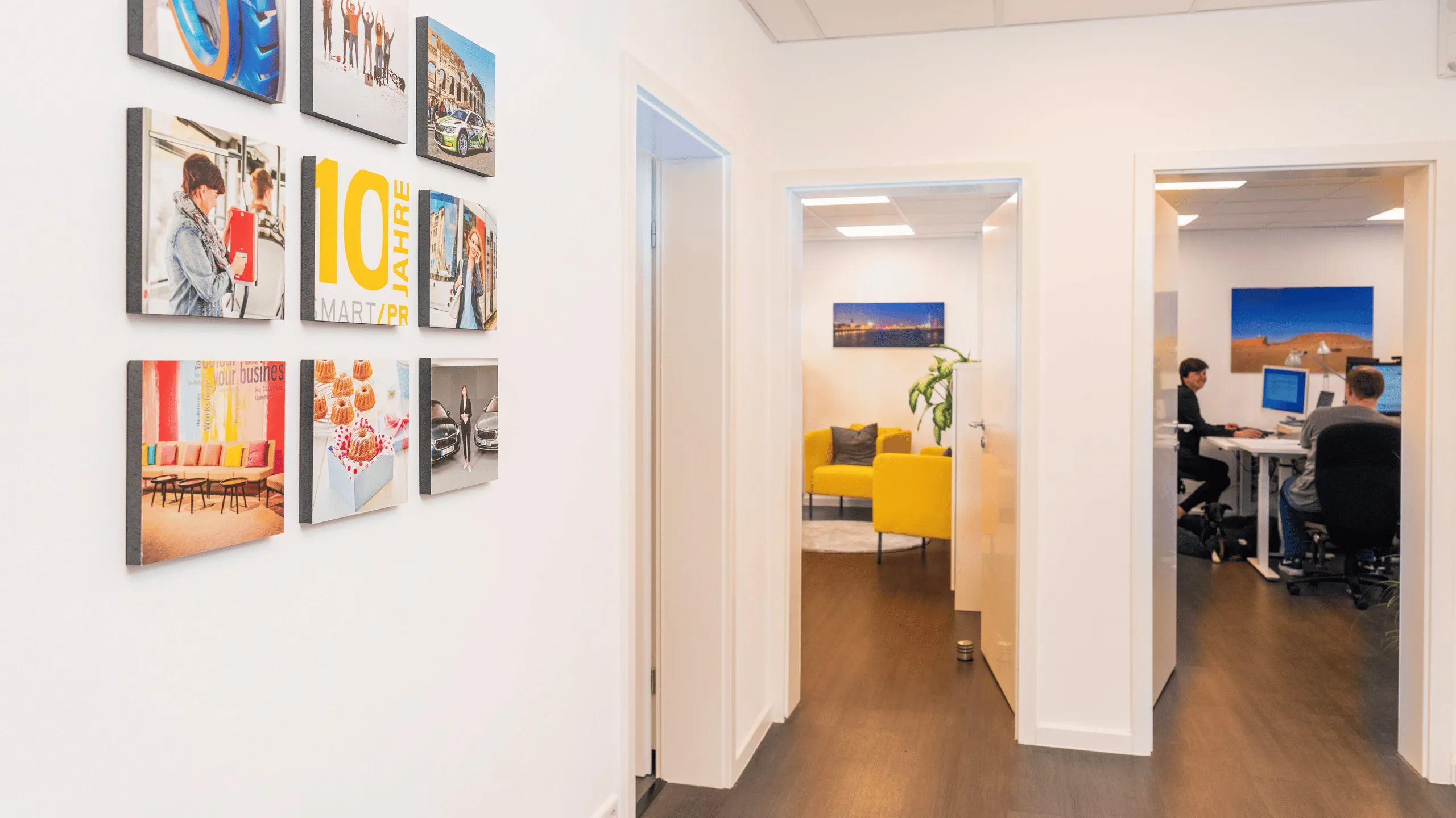 Symbolic image SMART PR GmbH at abacus alpha: Bright office corridor with wall decoration and view of modern, open workspaces.