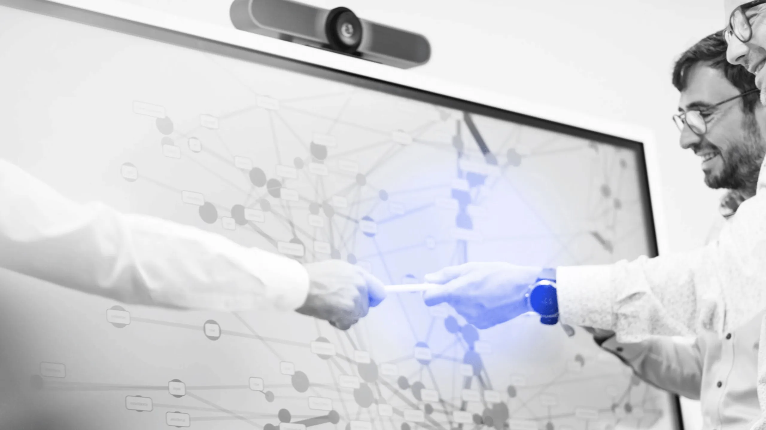 Symbolic image of Abacus neo GmbH at Abacus alpha: Two people in a modern office pass a pen in front of a large screen showing complex data visualizations.