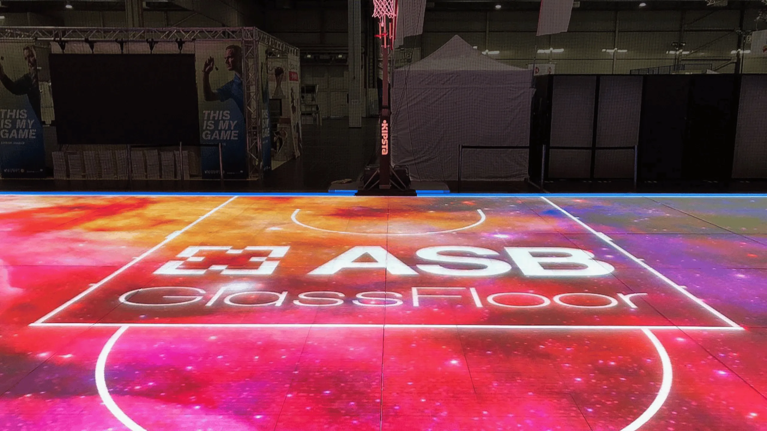 Symbolic image of ASB Rental Solutions GmbH at Abacus alpha: Illuminated LED sports flooring system from ASB GlassFloor in an event hall.
