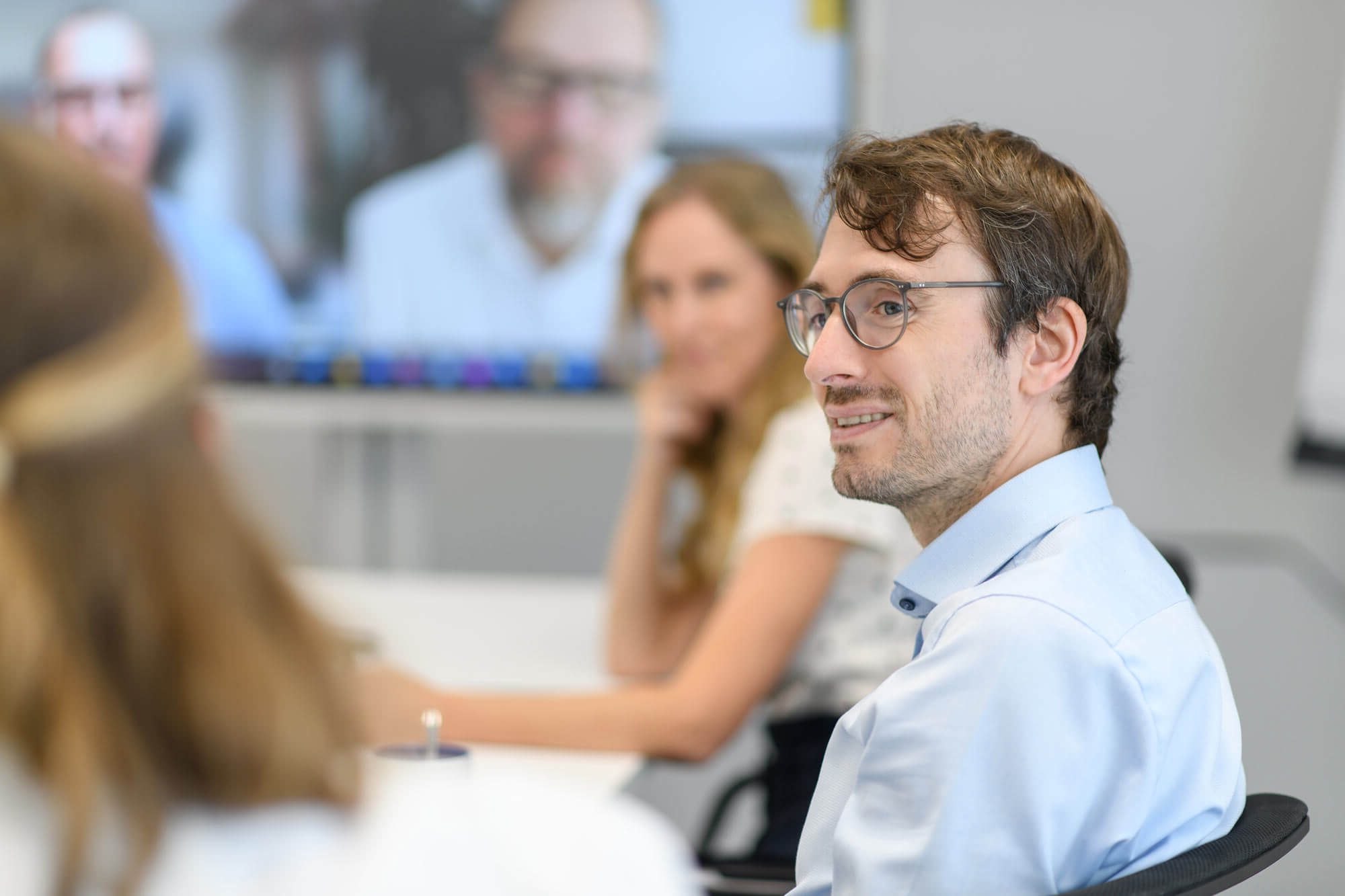 Abacus alpha in ein nachhaltiger Investor: Symbolbild Team mit Mitarbeiter auf unscharfem Hintergrund